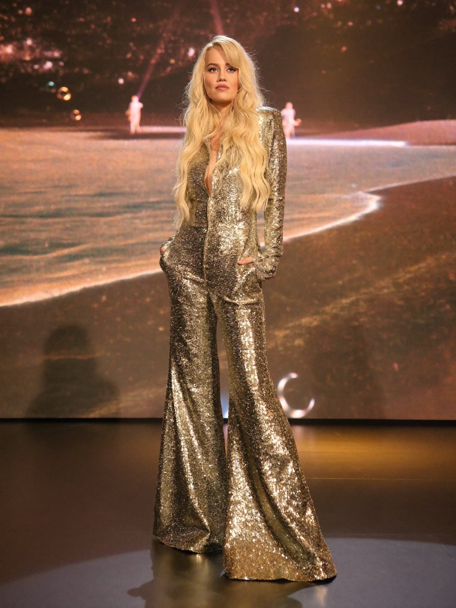 ABBA Voyage costume — Gold sequined jumpsuit with bell-bottoms.